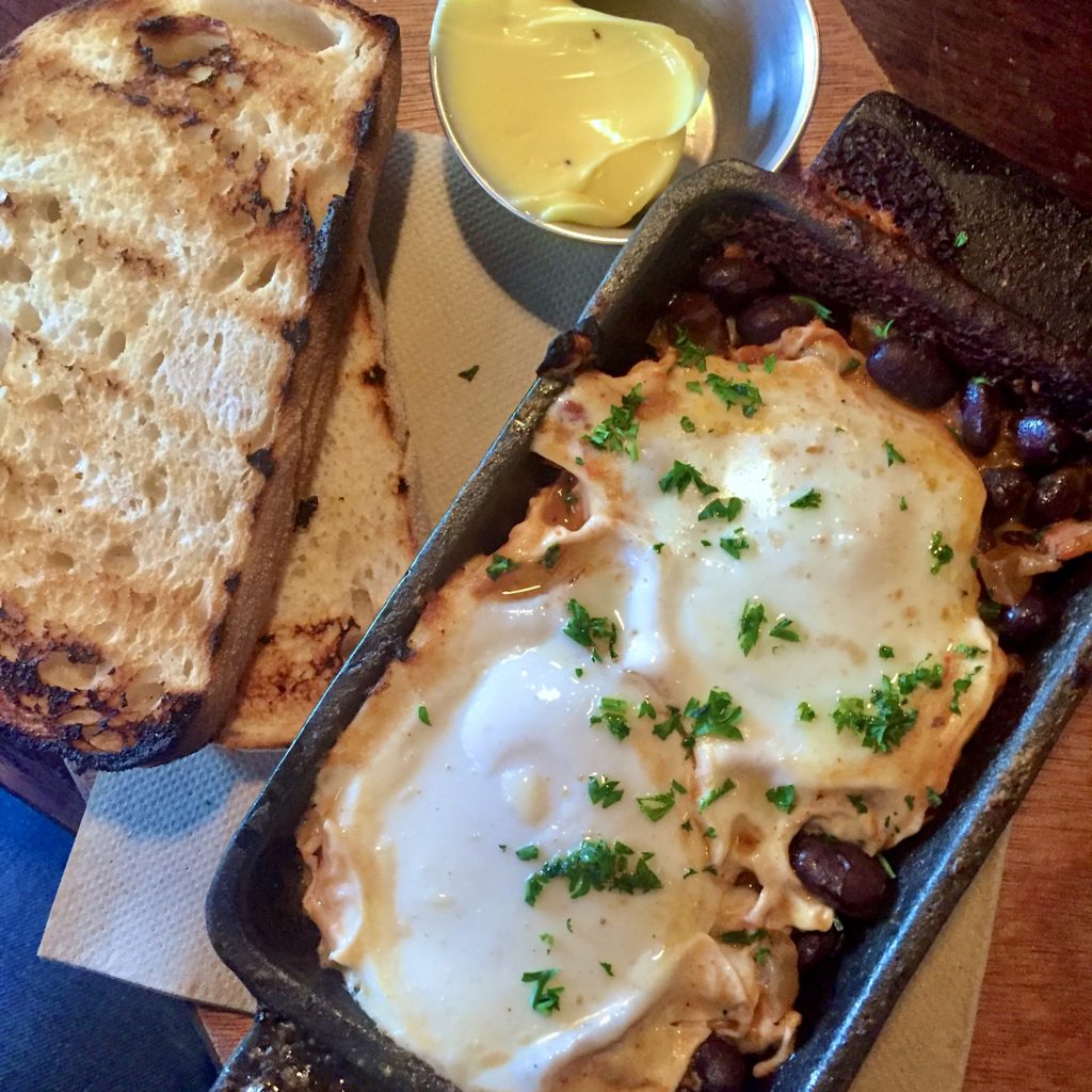 Eggs and beans in a cast iron with toast and butter