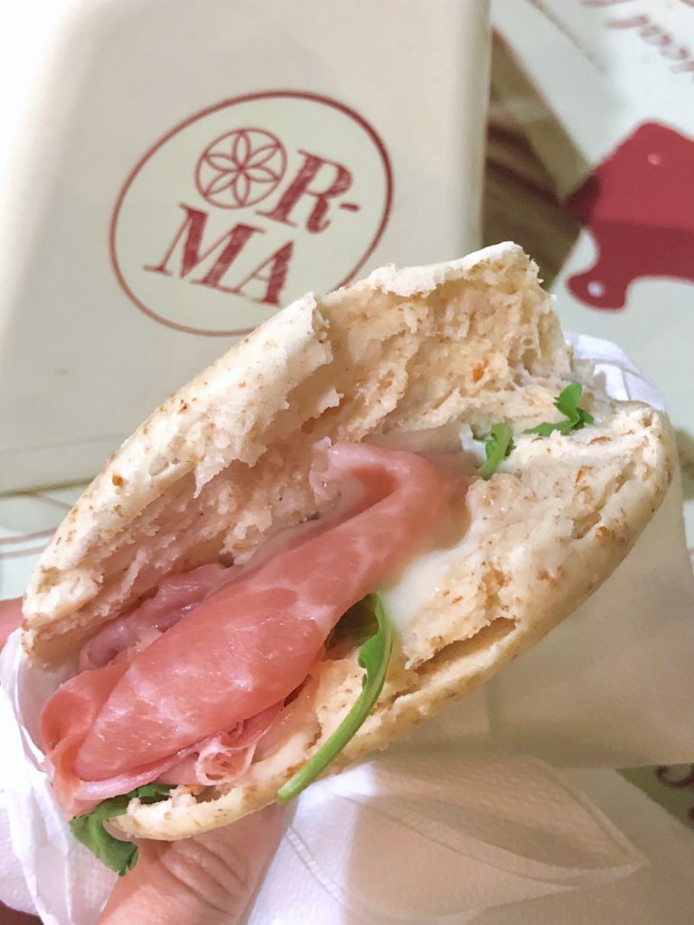 Sandwich of prosciutto, cheese, and greens in a tigelle