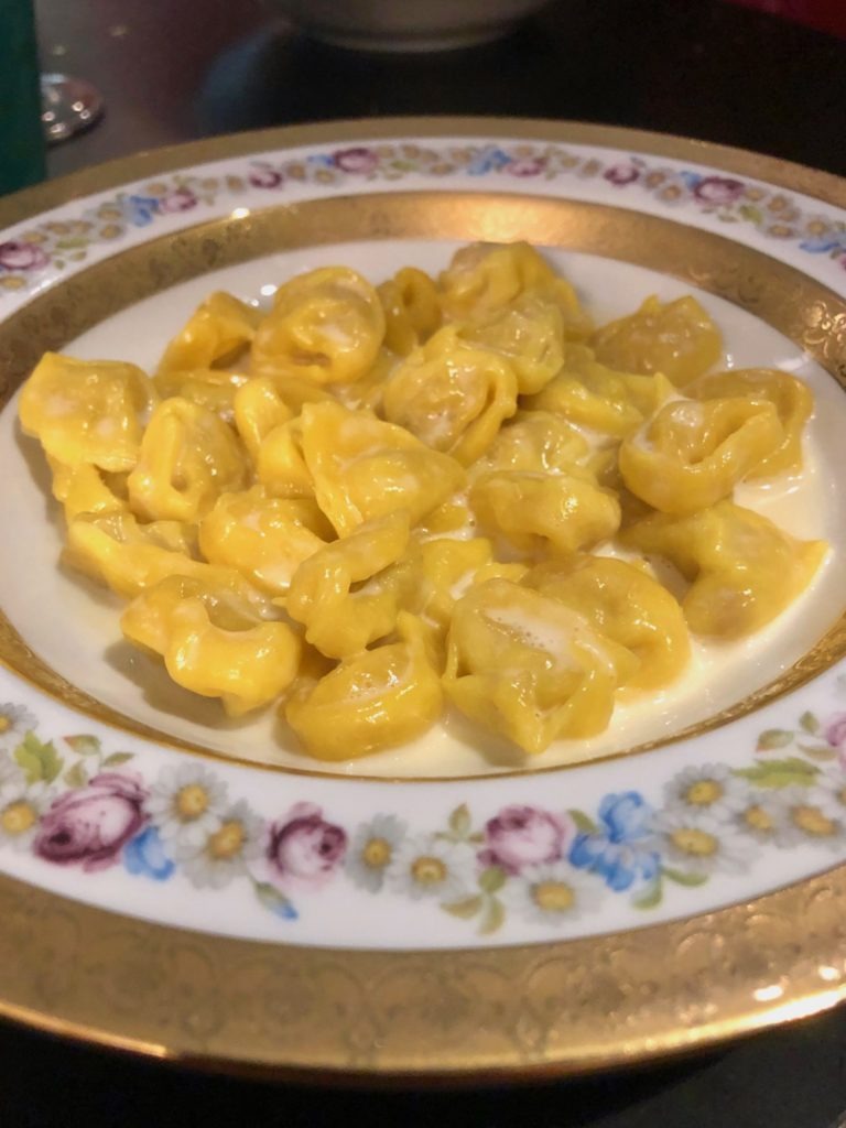 Flowered dish filled with tortellini in Parmigiano-Reggiano fondue