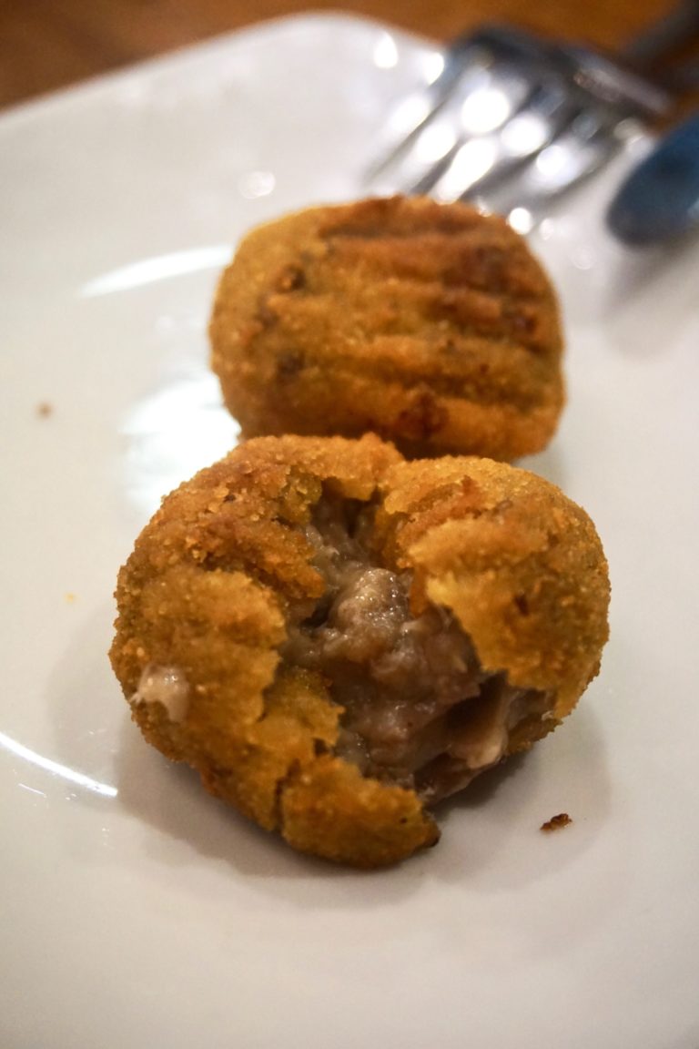 Two croquettes of txuleta on a white plate