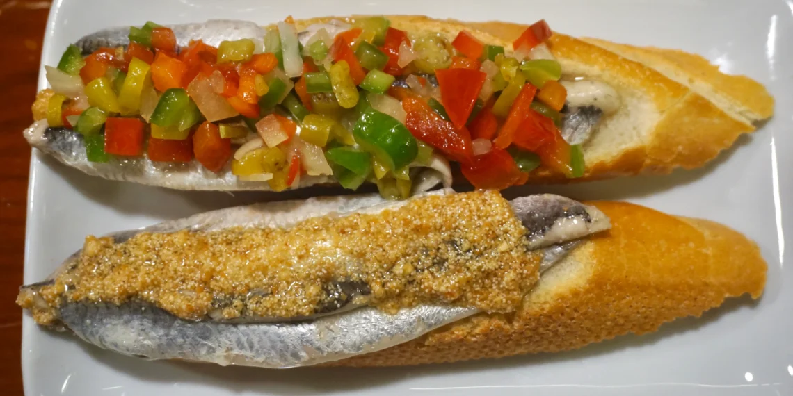 Bar Txepetxa pintxos in San Sebastián. Anchovy on bread with chopped peppers and onion in back and anchovy on bread with spider crab cream in the front.