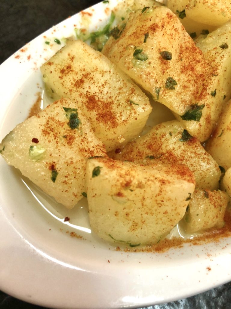 Cubed potatoes on a white plate with smoked paprika
