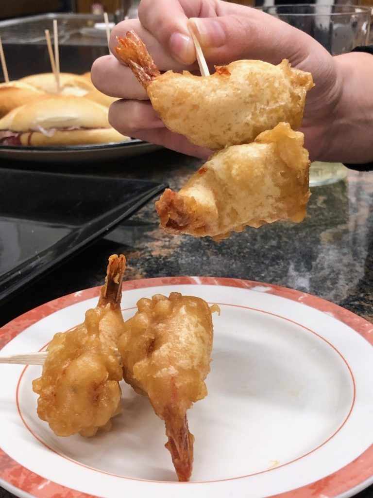 Two fried prawns on a skewer