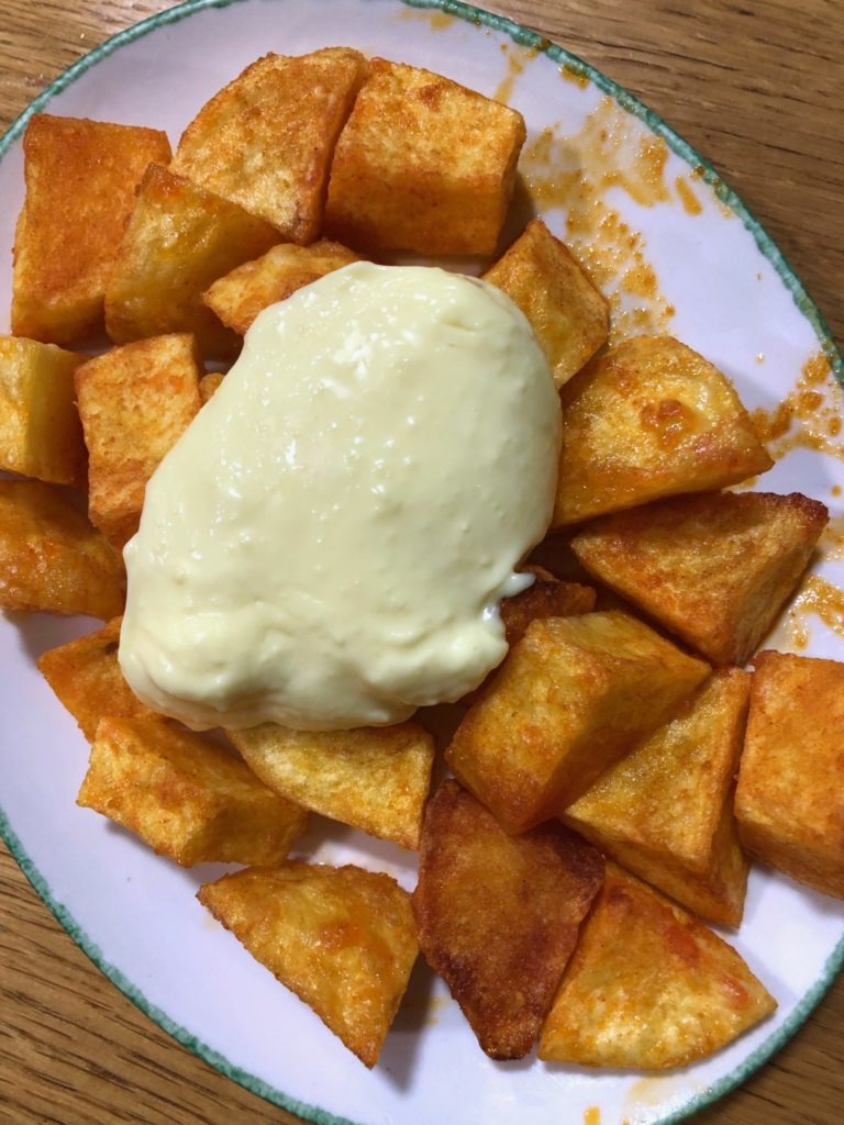 Patata bravas on a white plate