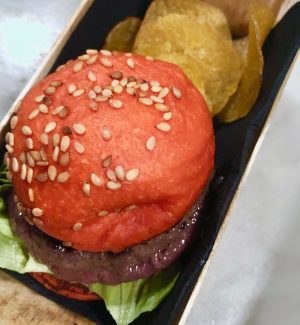 Mini kobe burger with a red bun with a side of plantain chips